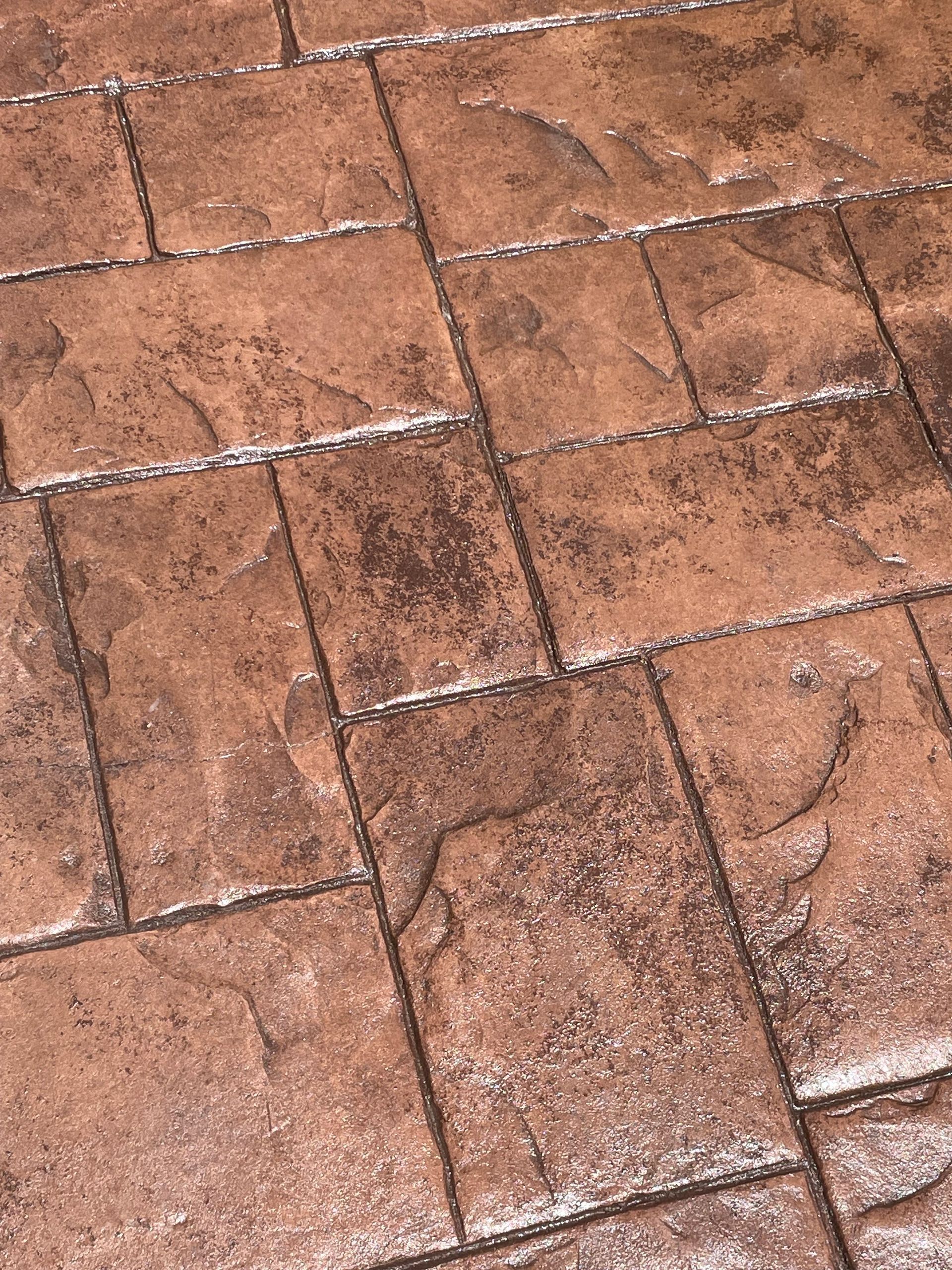 A close up of a brick floor with a brick pattern.