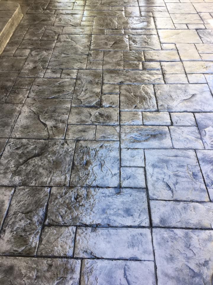 A close up of a concrete floor with a brick pattern.