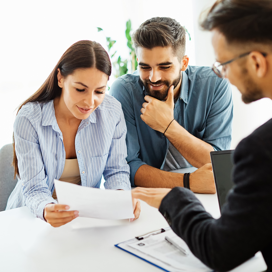 A man and a woman are sitting at a table looking at a piece of paper.
