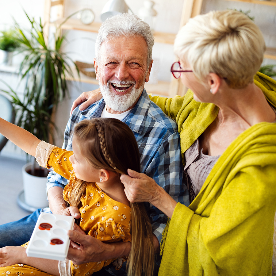 A man and woman are sitting on a couch with a little girl.