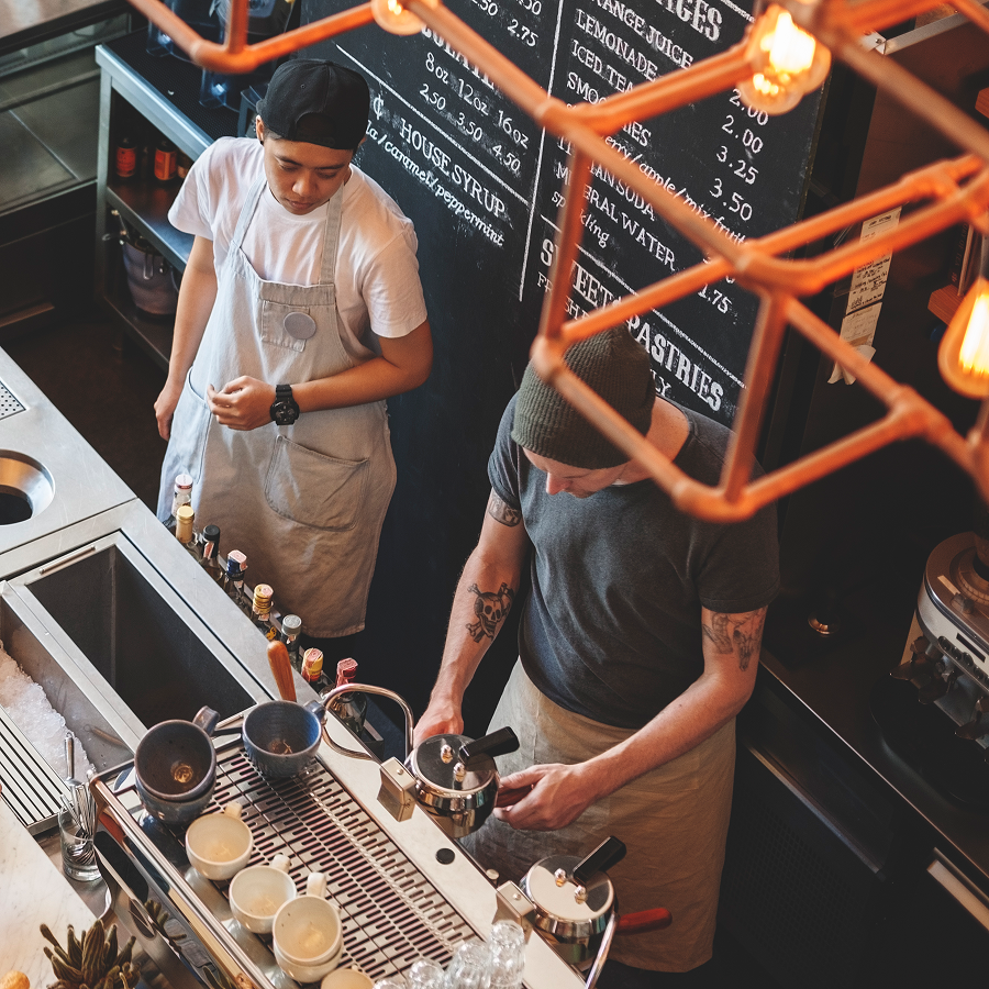 Two men are standing in front of a blackboard that says pastries
