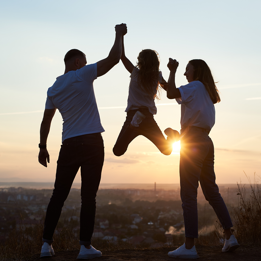 A family giving each other a high five at sunset
