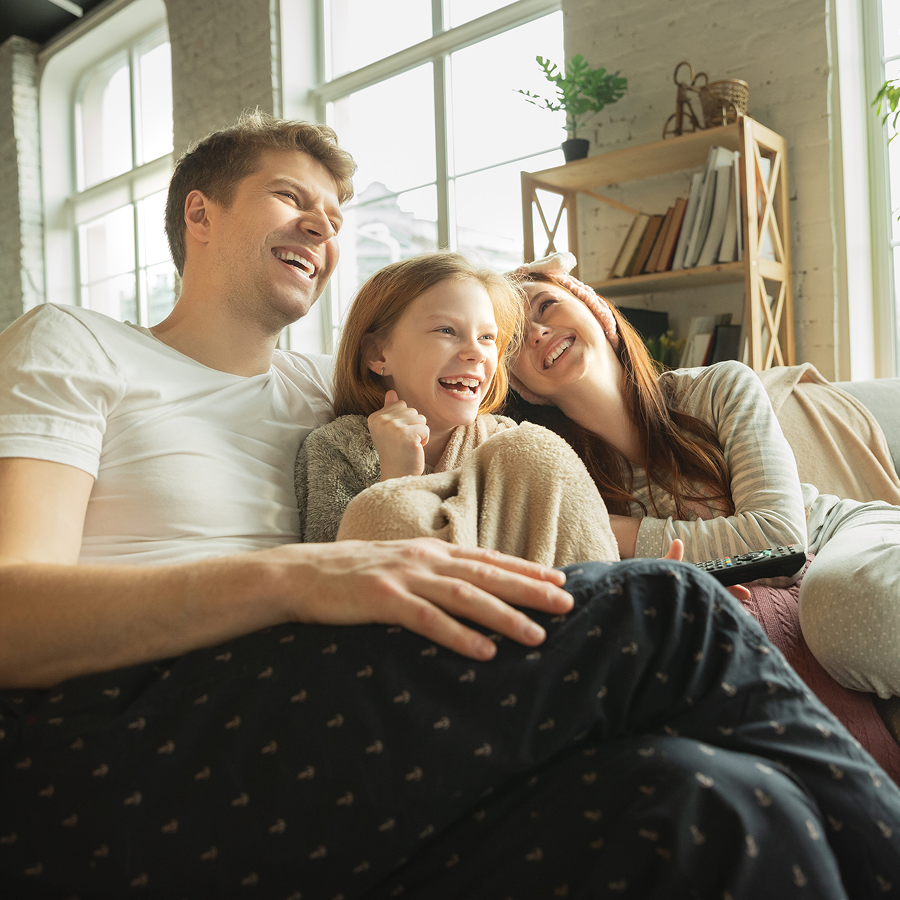 A family is sitting in the back of a car at sunset.