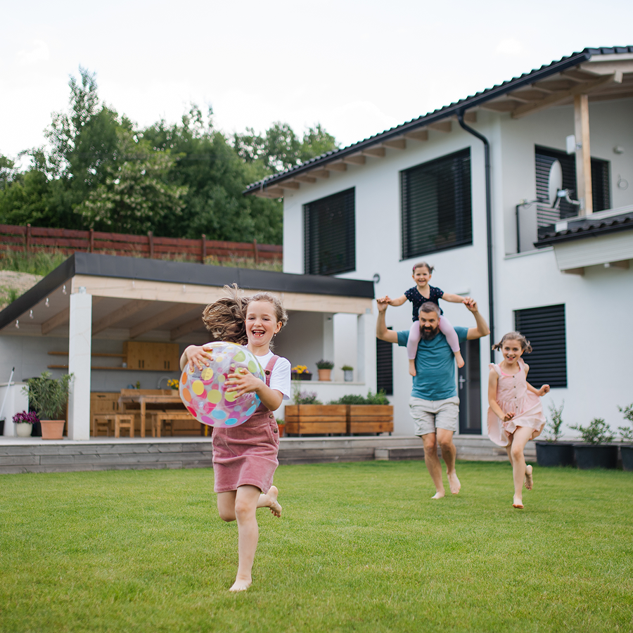 A family is playing in the backyard of their house.