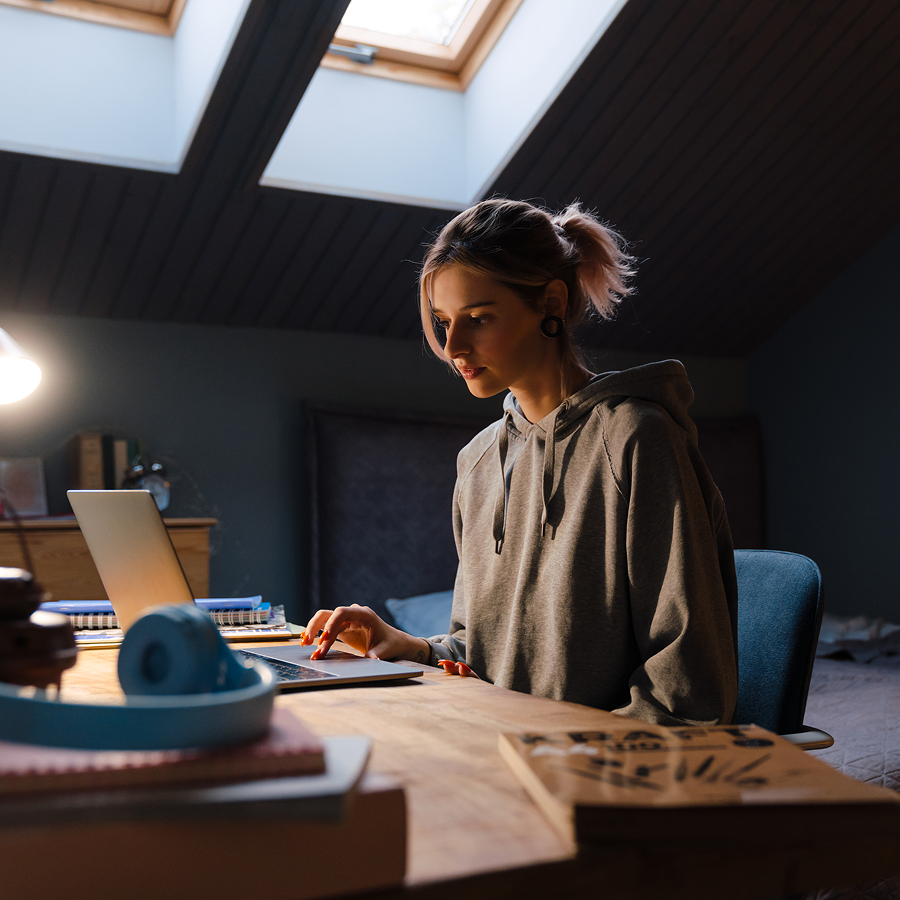 A woman is sitting at a desk using a laptop computer