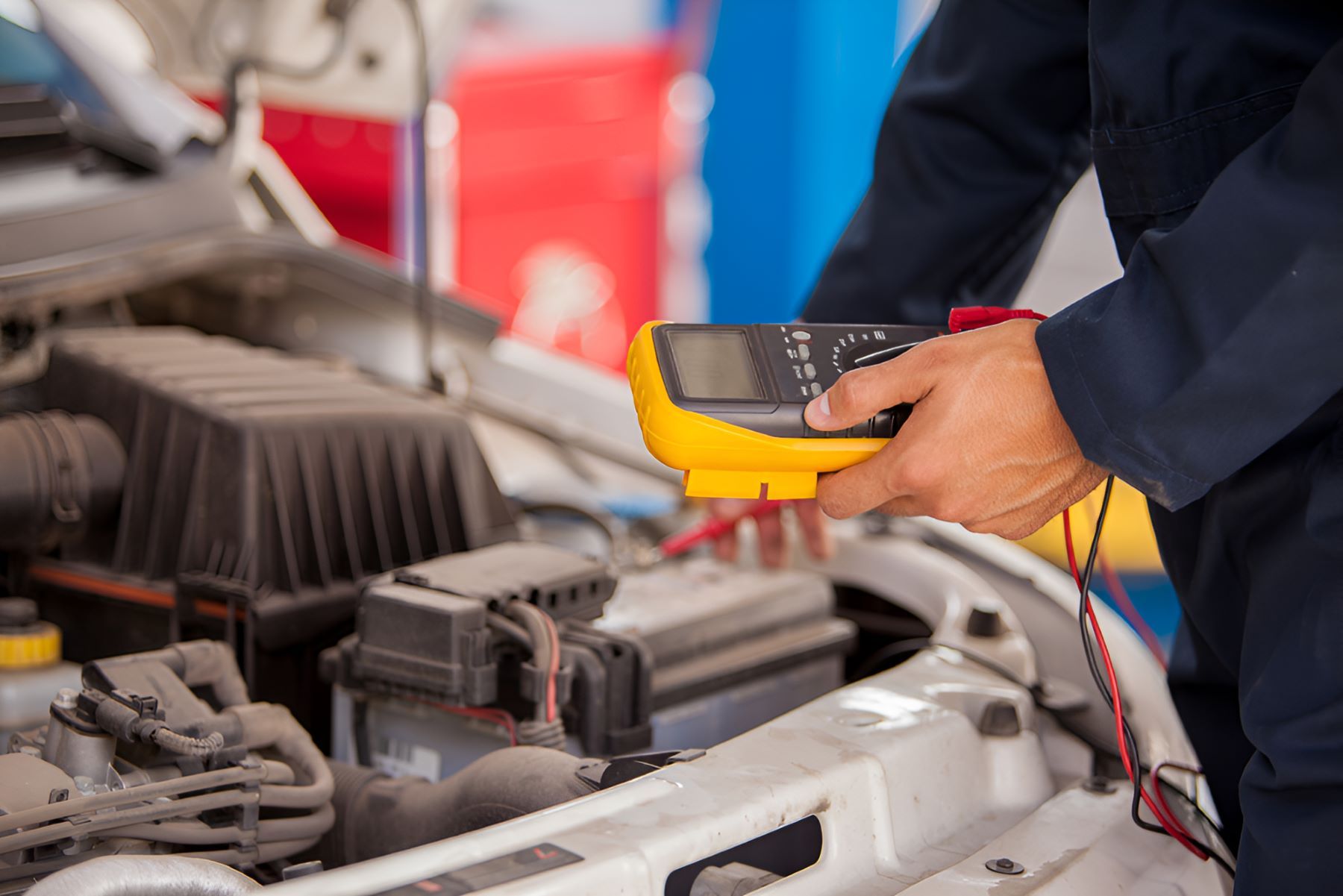 A Mechanic Is Working On A Car With A Multimeter — All Models Service Centre In Port Macquarie, NSW