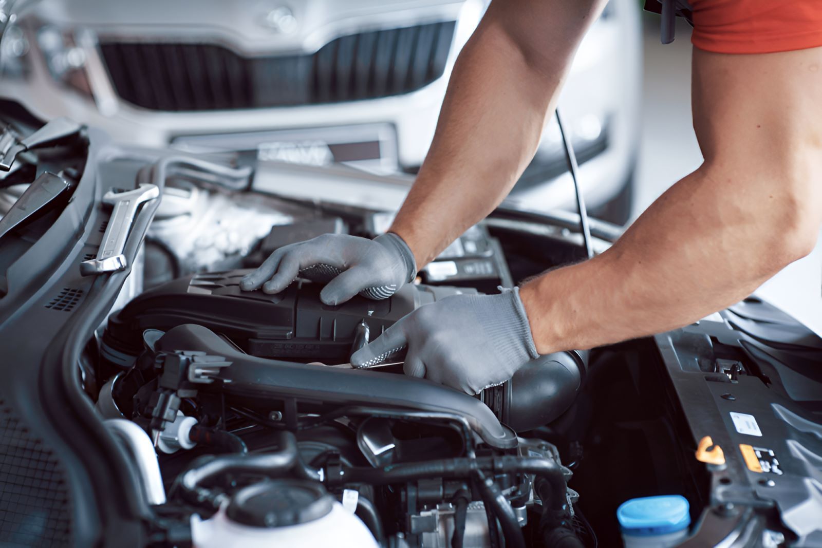 A Man Is Working On The Engine Of A Car — All Models Service Centre In Laurieton, NSW