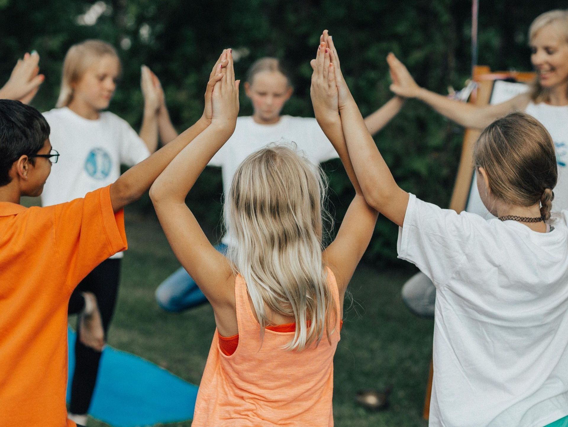 Children standing in a circle joined at the arms doing a mindfulness balancing activity