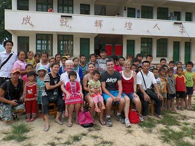 Group of children and teachers outside a school in China