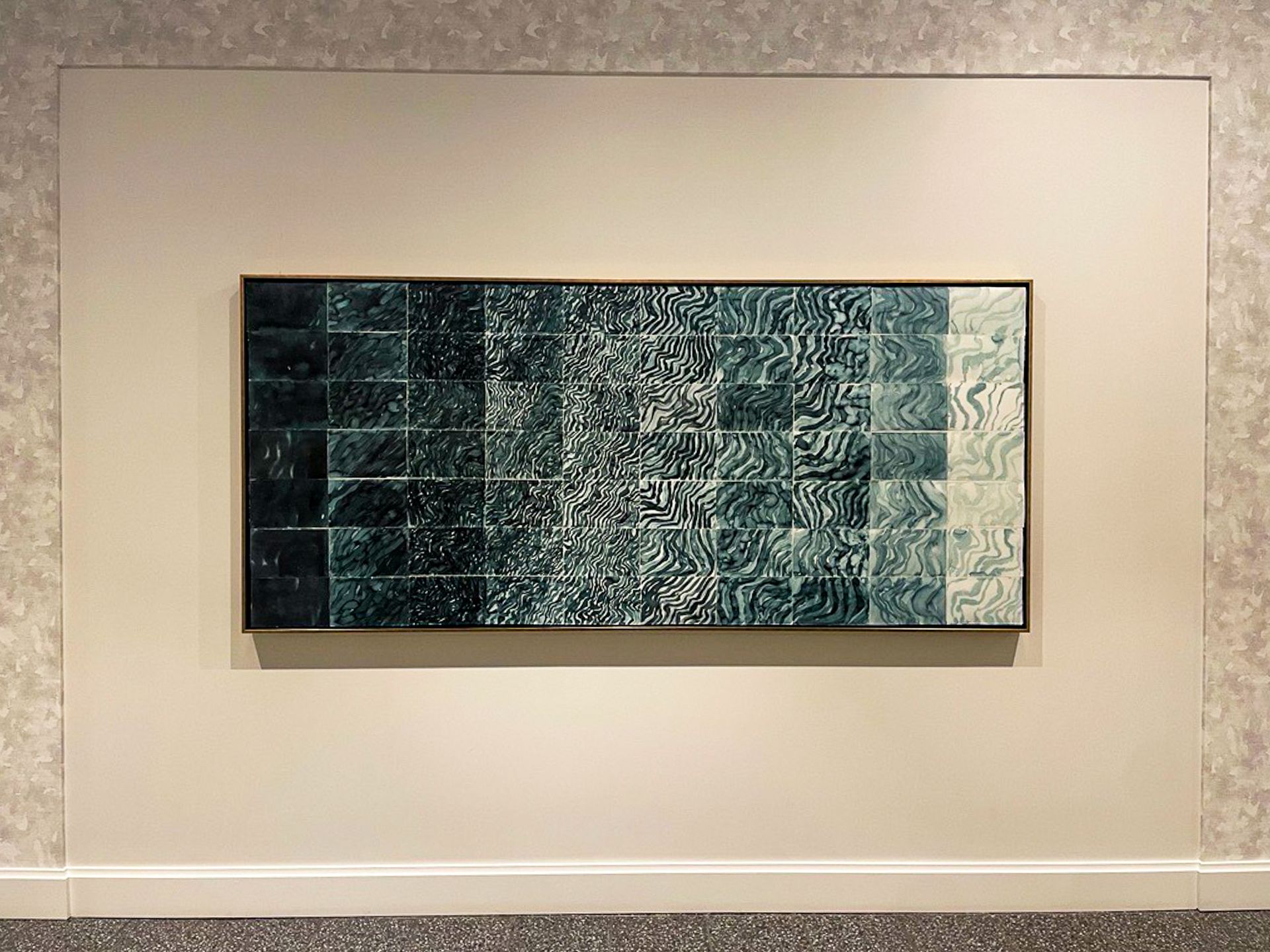 A large painting is hanging on a white wall
