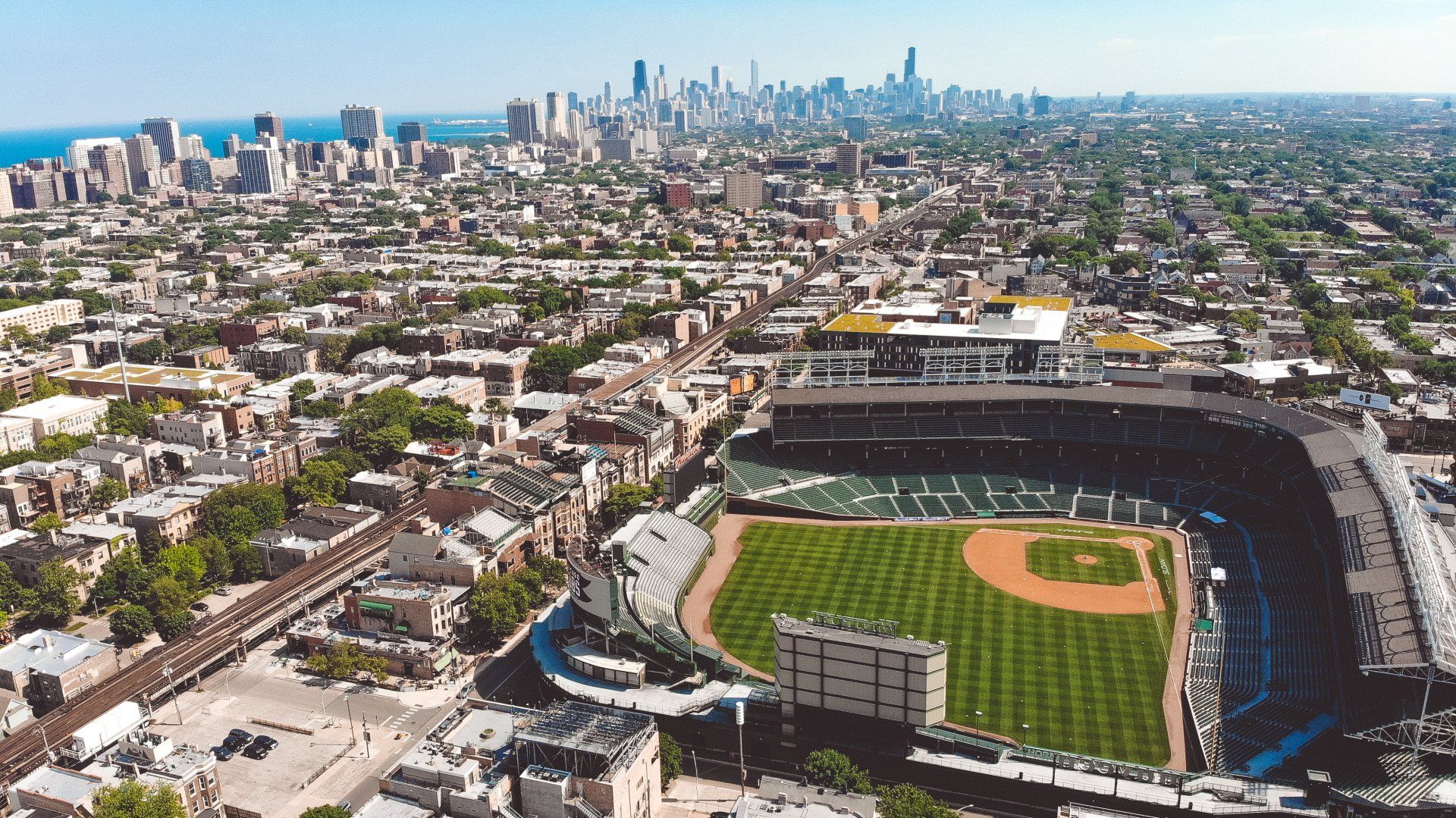 An aerial view of a baseball stadium with a city in the background around Lakeview.