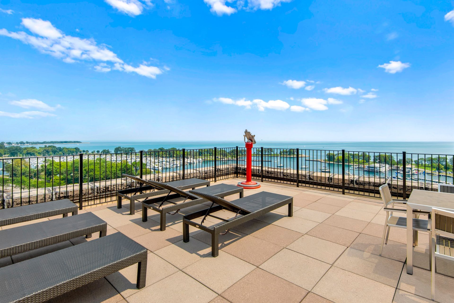 A rooftop deck with a view of the water and a telescope at The Belmont by Reside.