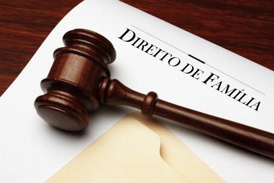 Um martelo de madeira fica em cima de um pedaço de papel que diz direito de família