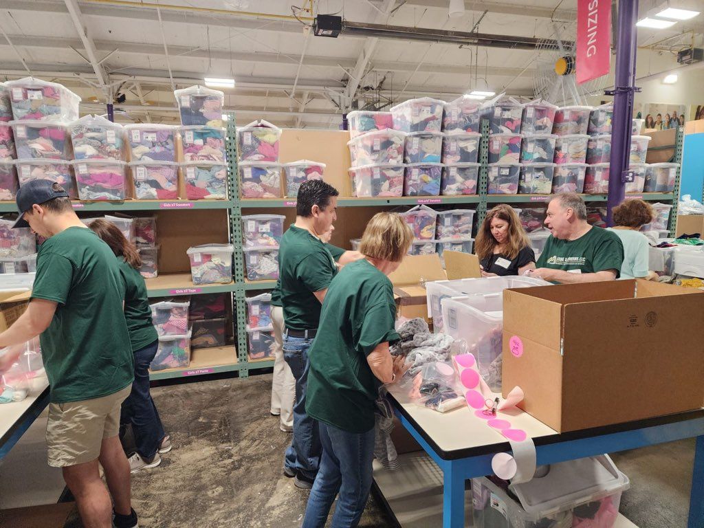 Sorting and packing clothing at Cradles 2 Crayons, Boston Giving Factory