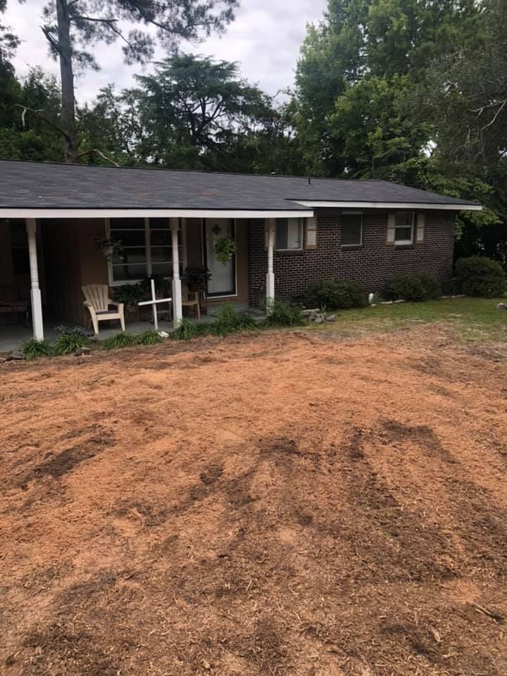 A single-story brick house with a brown yard and overcast sky.