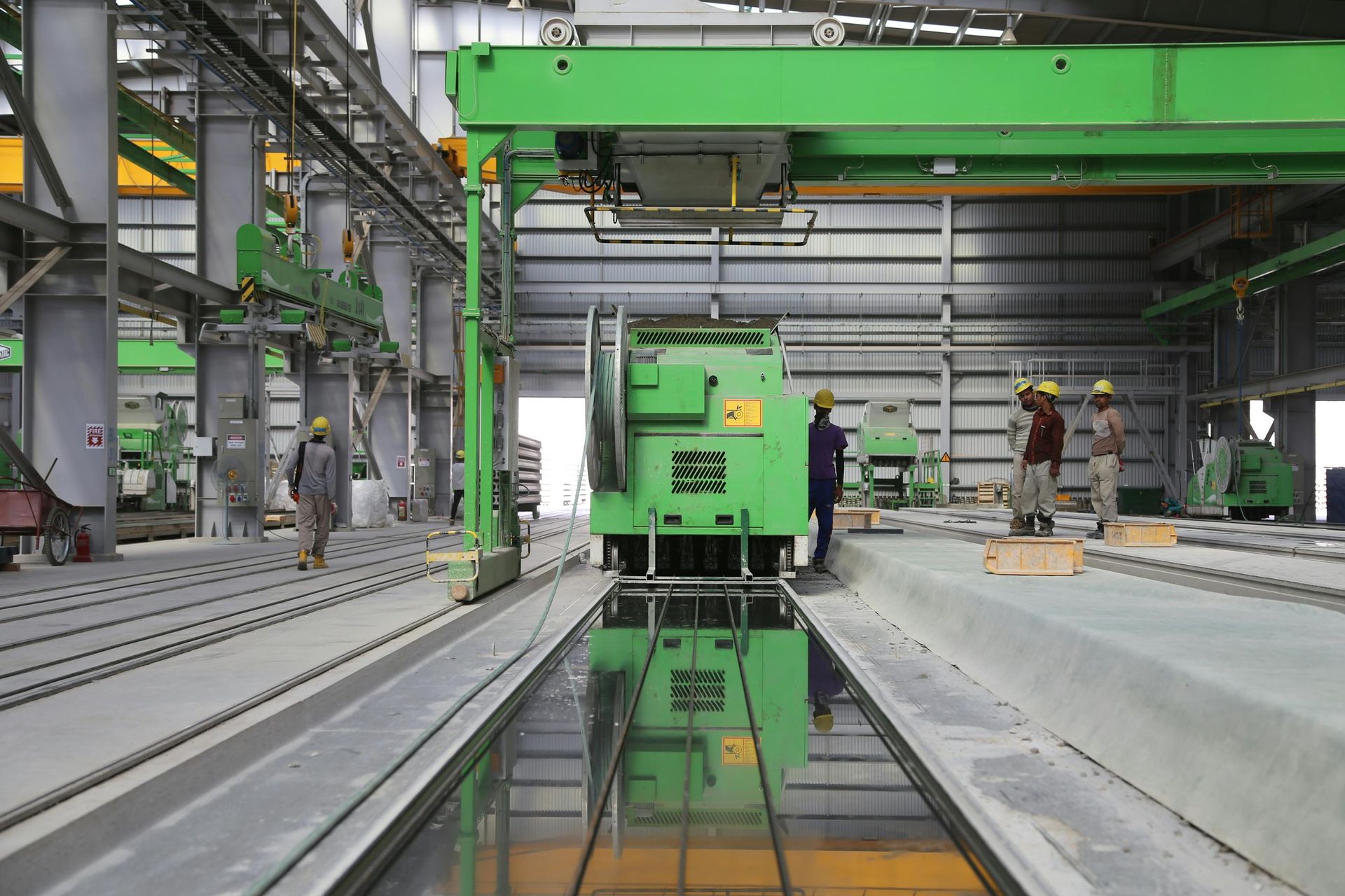 A green crane is sitting in the middle of a large building.
