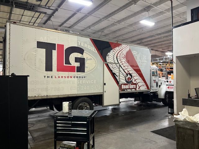 A tlg truck is parked in a garage