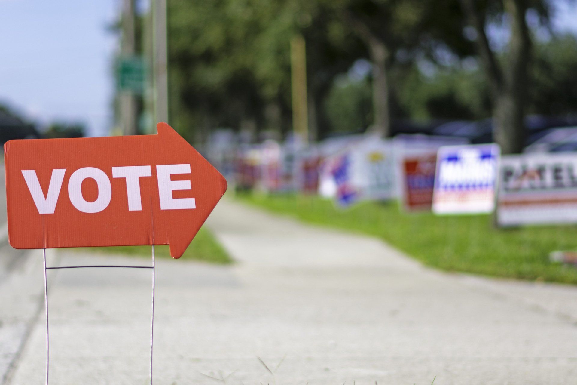 A Red Vote Sign is Sitting on the Side of the Road