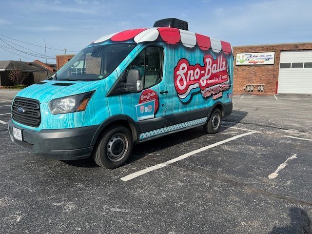 A blue van is parked in a parking lot