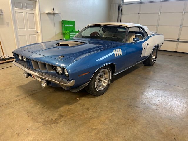 A blue and white muscle car is parked in a garage