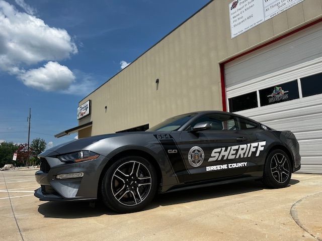 A sheriff 's car is parked in front of a building