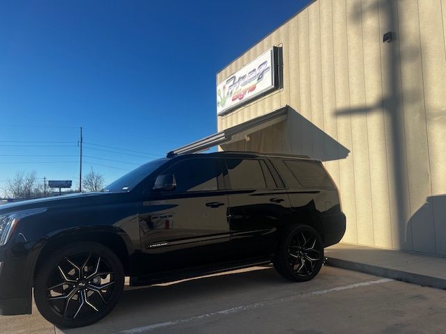 A black suv is parked in front of a building