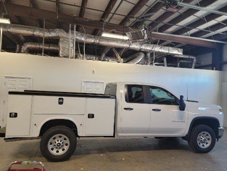 A White Truck With a Utility Bed is Parked in a Garage