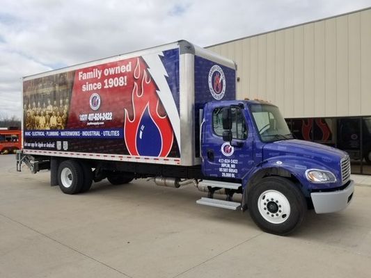 A Blue Truck is Parked in Front of a Building.
