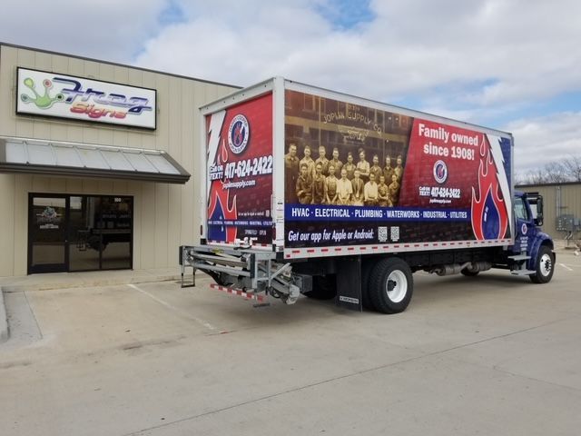 A large truck is parked in front of a building.
