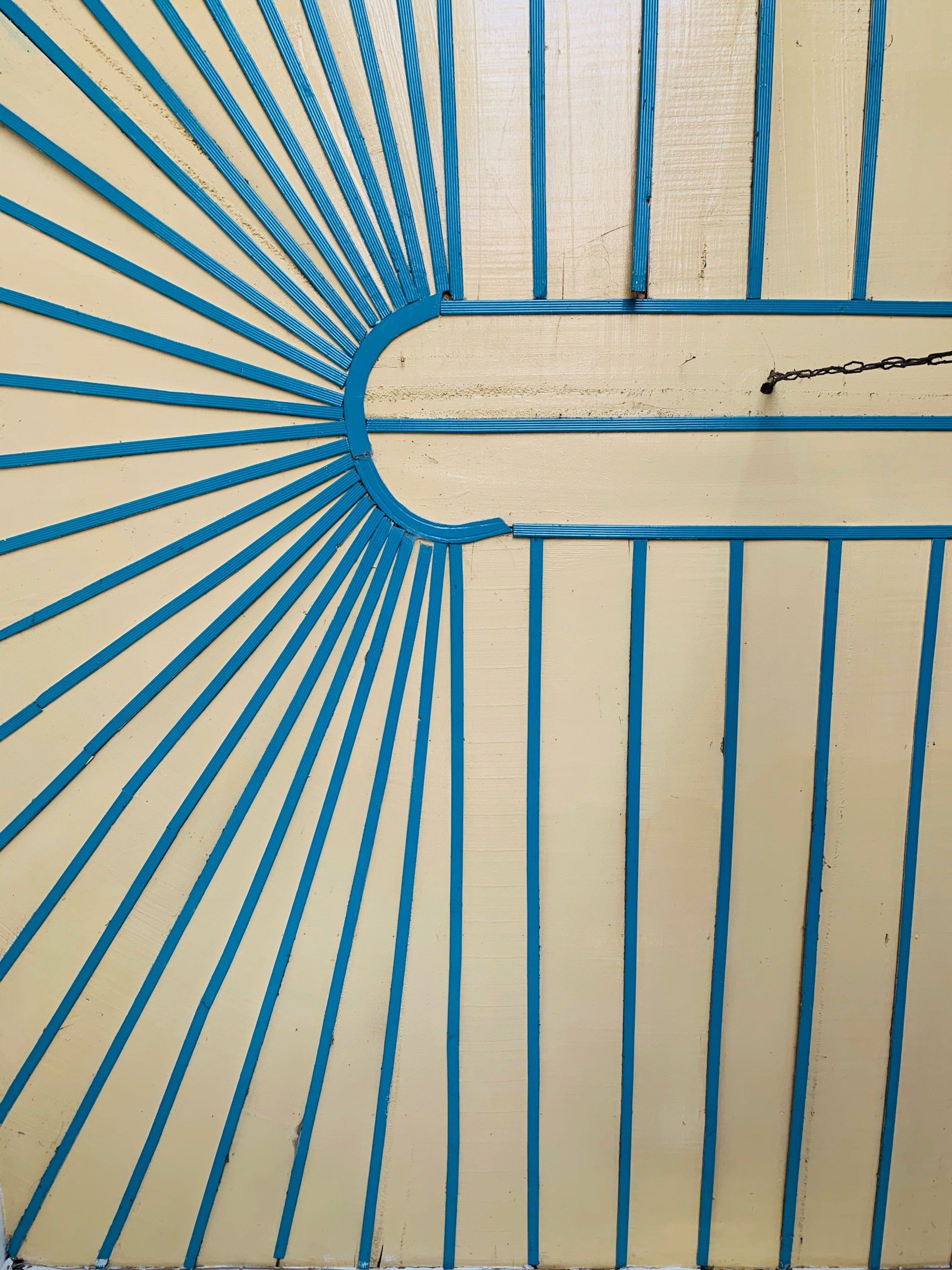 A close up of a blue fence on a white wall