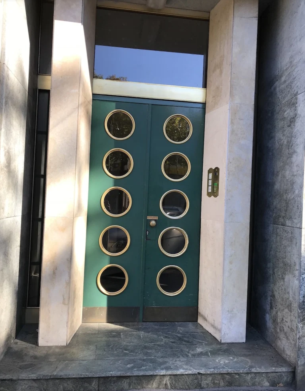 A green door with gold circles on it
