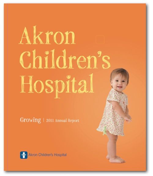 Akron Children’s Hospital annual report cover with an orange background and a child standing at right