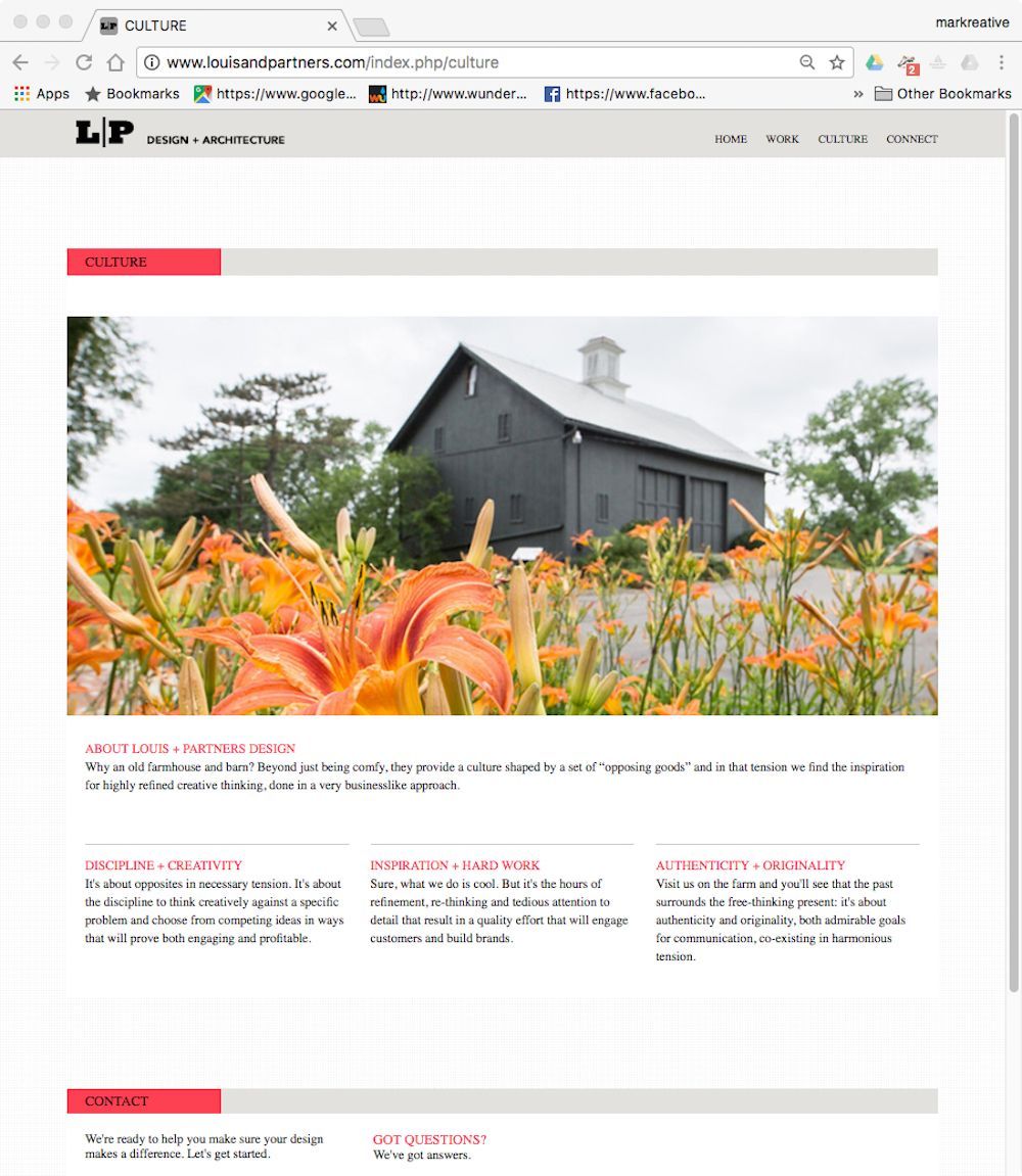Barn-style black building behind orange flowers and trees in a bright garden scene