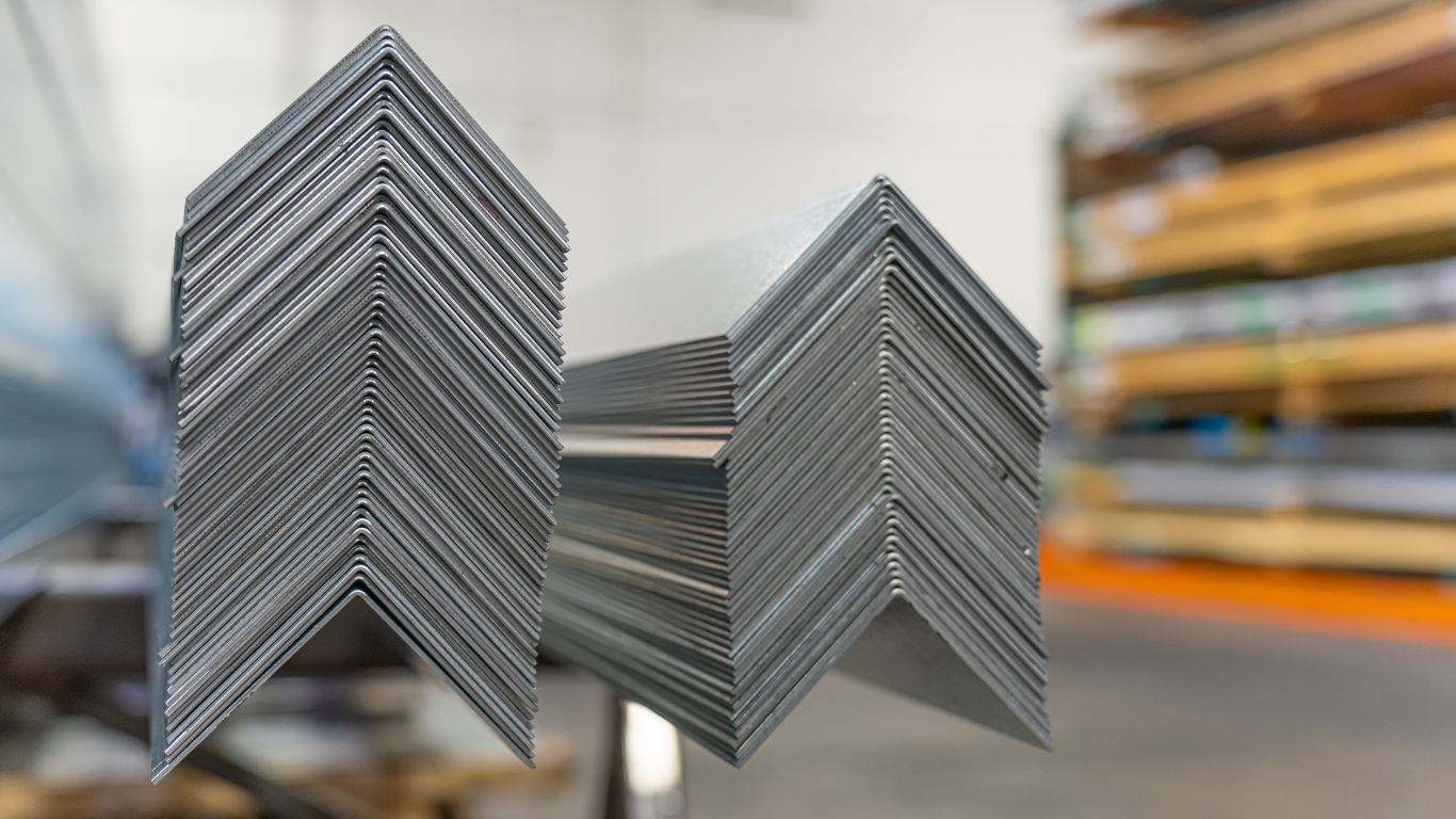 Black metal gate in front of a modern building with palm trees and landscaping.