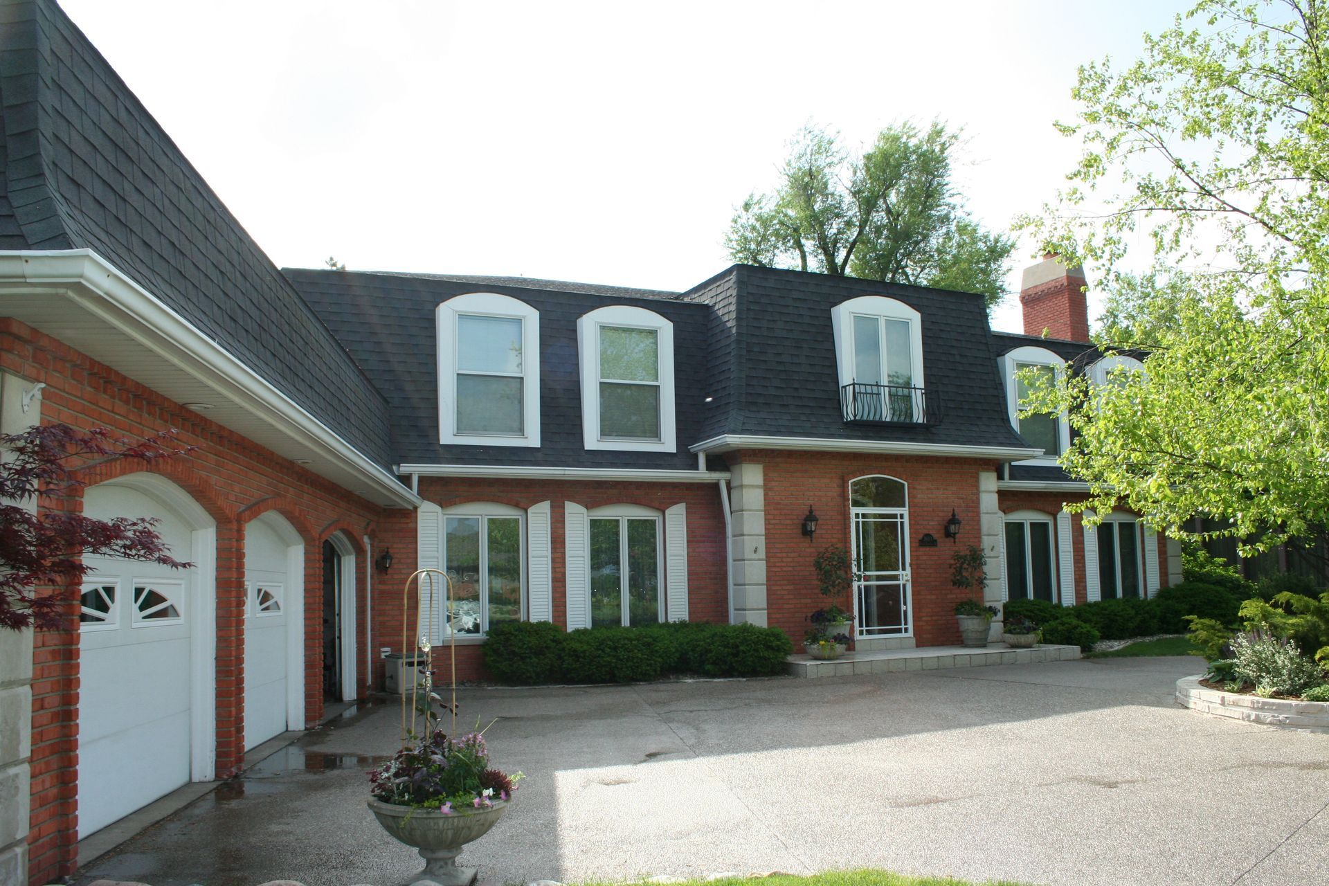 Front view of an elegant home showcasing a Kreiling-installed asphalt shingle mansard roof