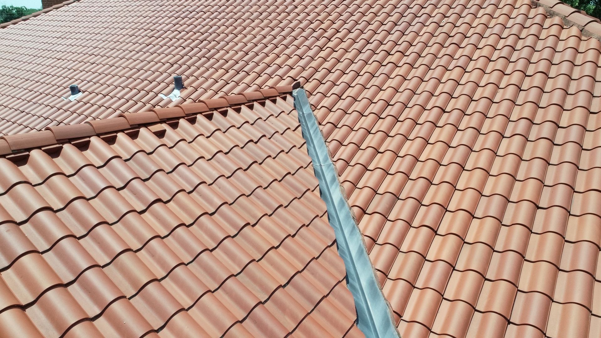 Clay tile roof with custom sheet metal valley and lead flashings by Kreiling Roofing