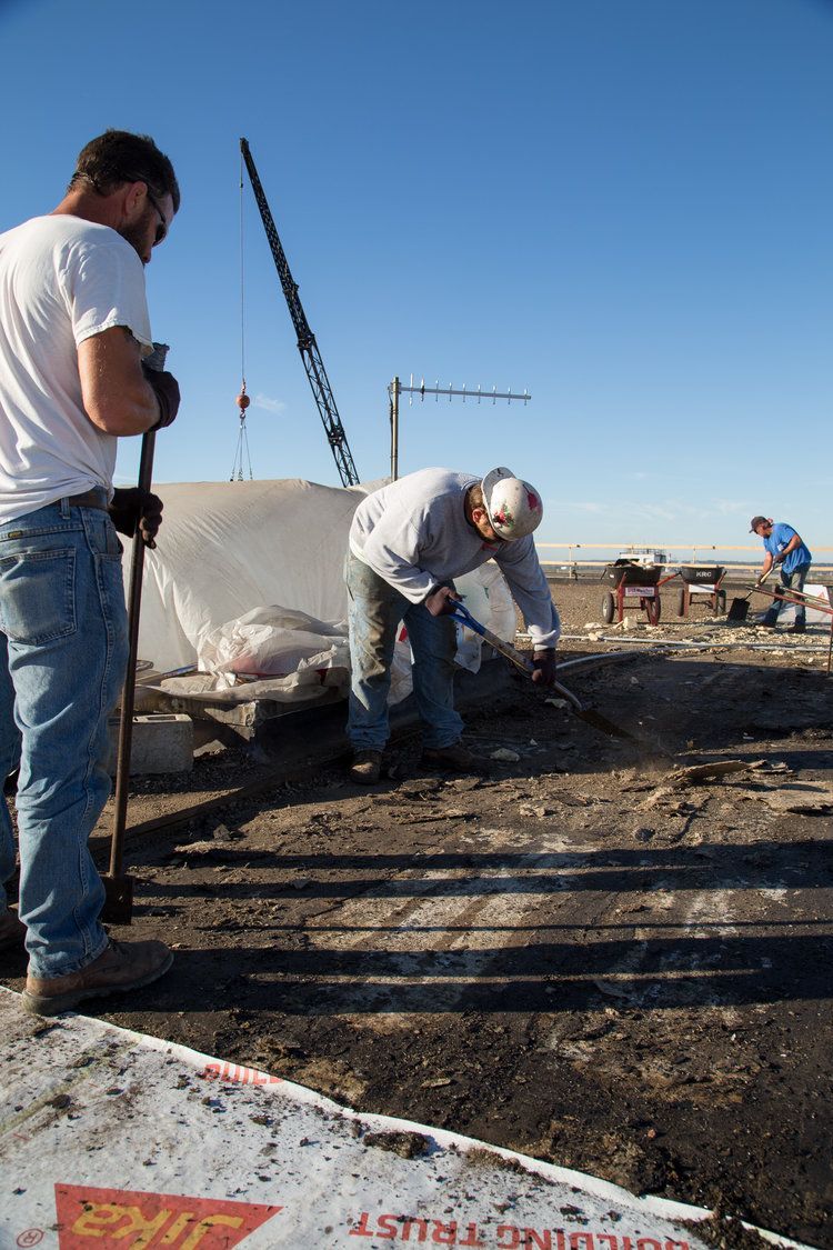 Workers tearing off an old built-up gravel roof