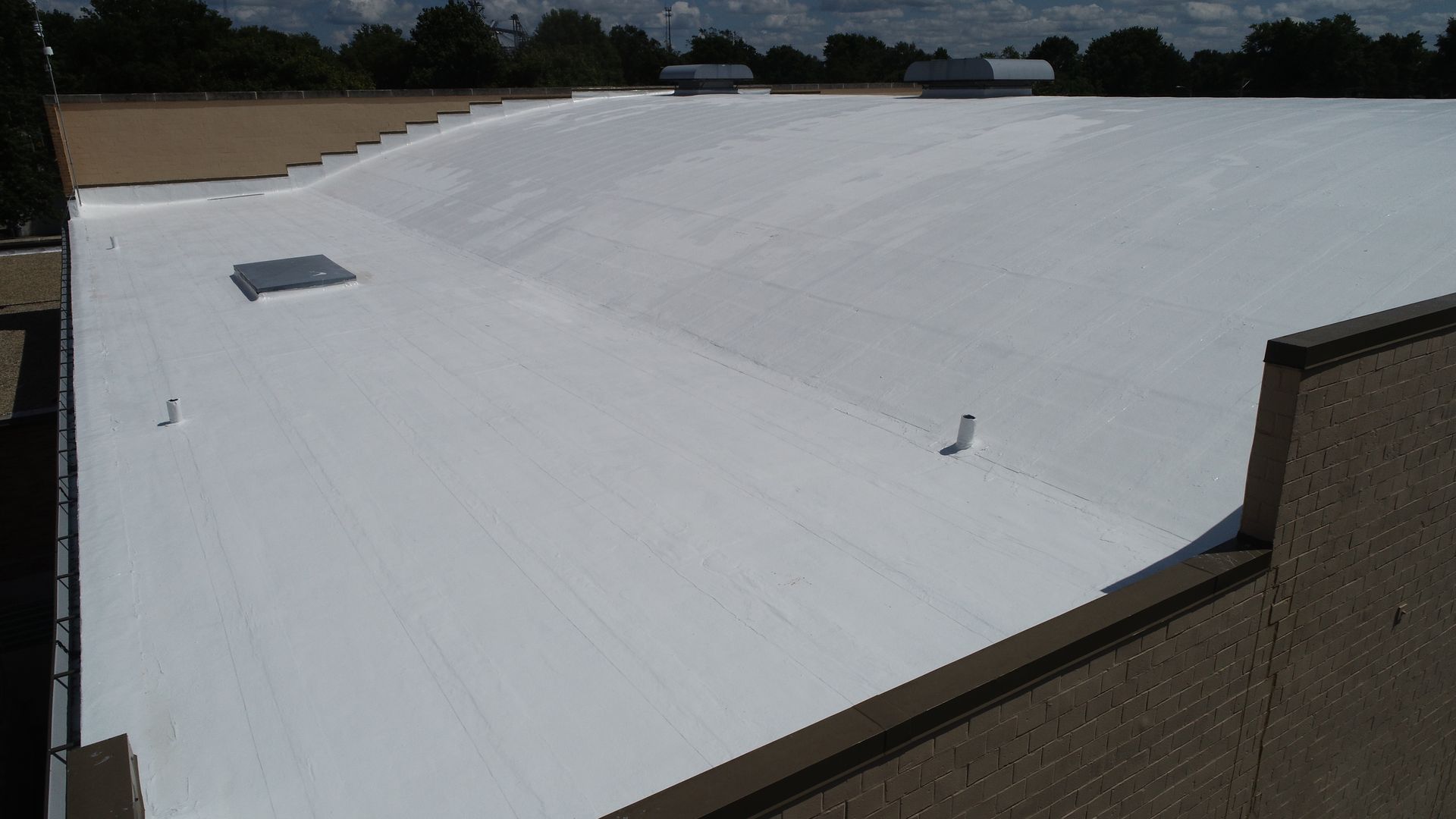 Reflective white roof coating on a distinctively arched barrel roof architecture
