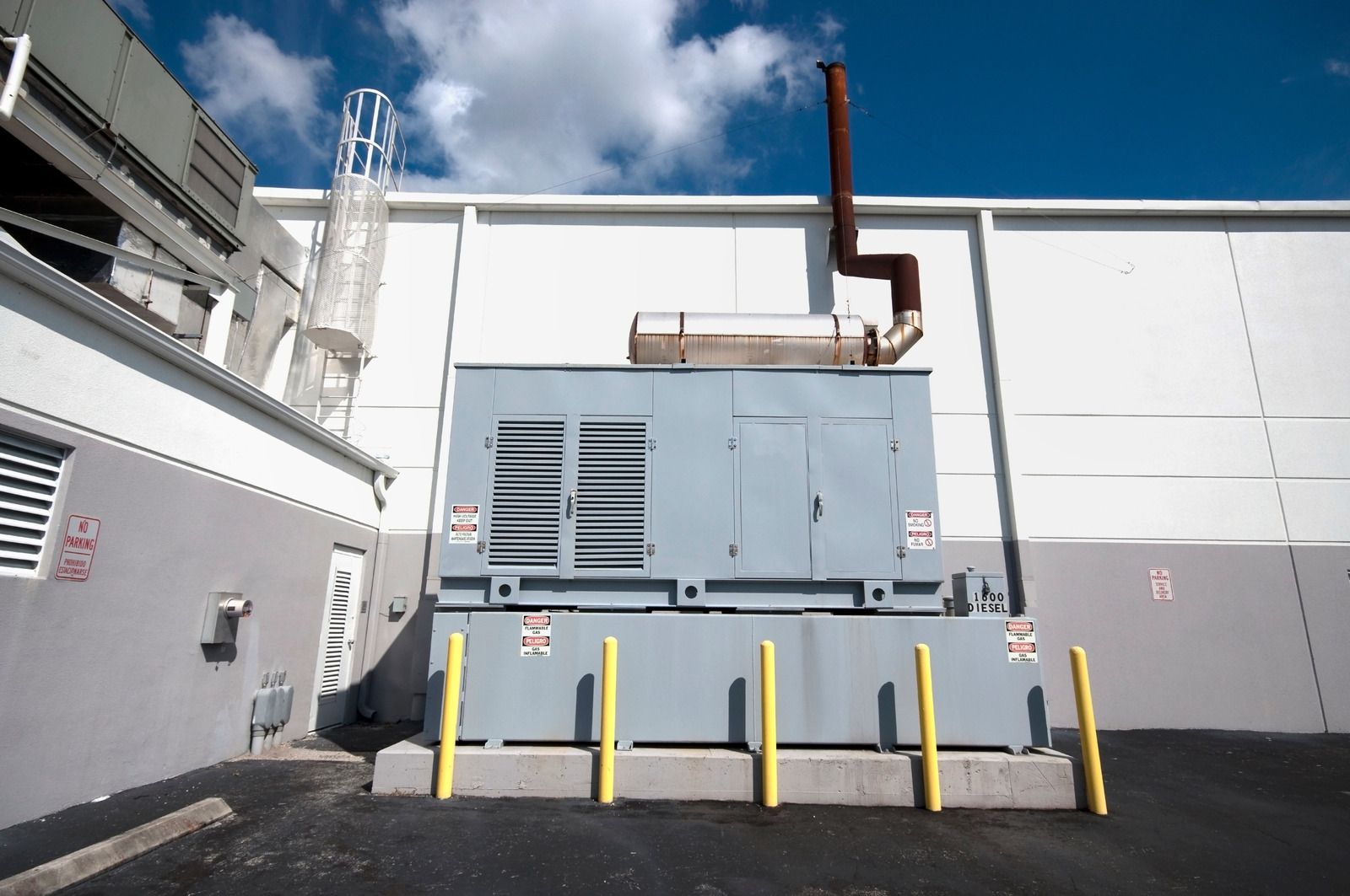 A large generator is sitting outside of a building