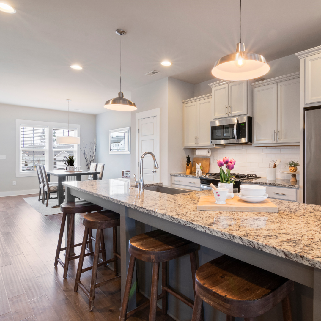 A kitchen with granite counter tops and wooden stools