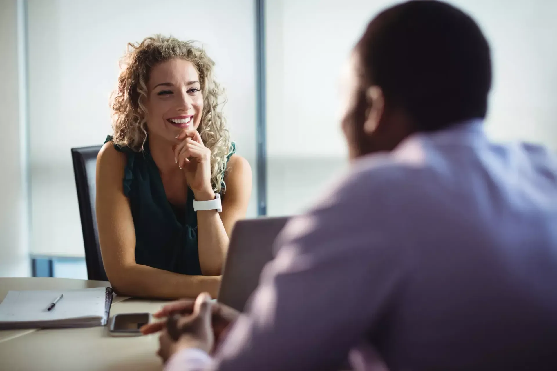 Um homem e uma mulher estão sentados à mesa conversando um com o outro.
