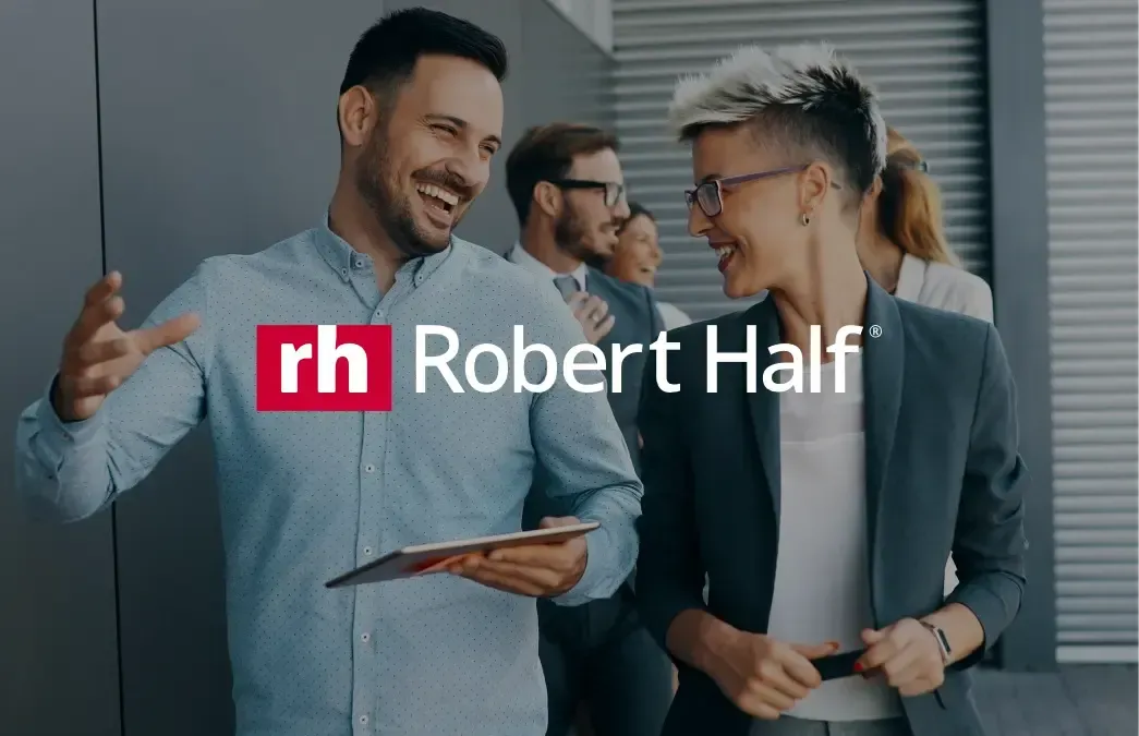 Um homem e uma mulher estão de pé, um ao lado do outro, em frente a um logotipo da Robert Half.