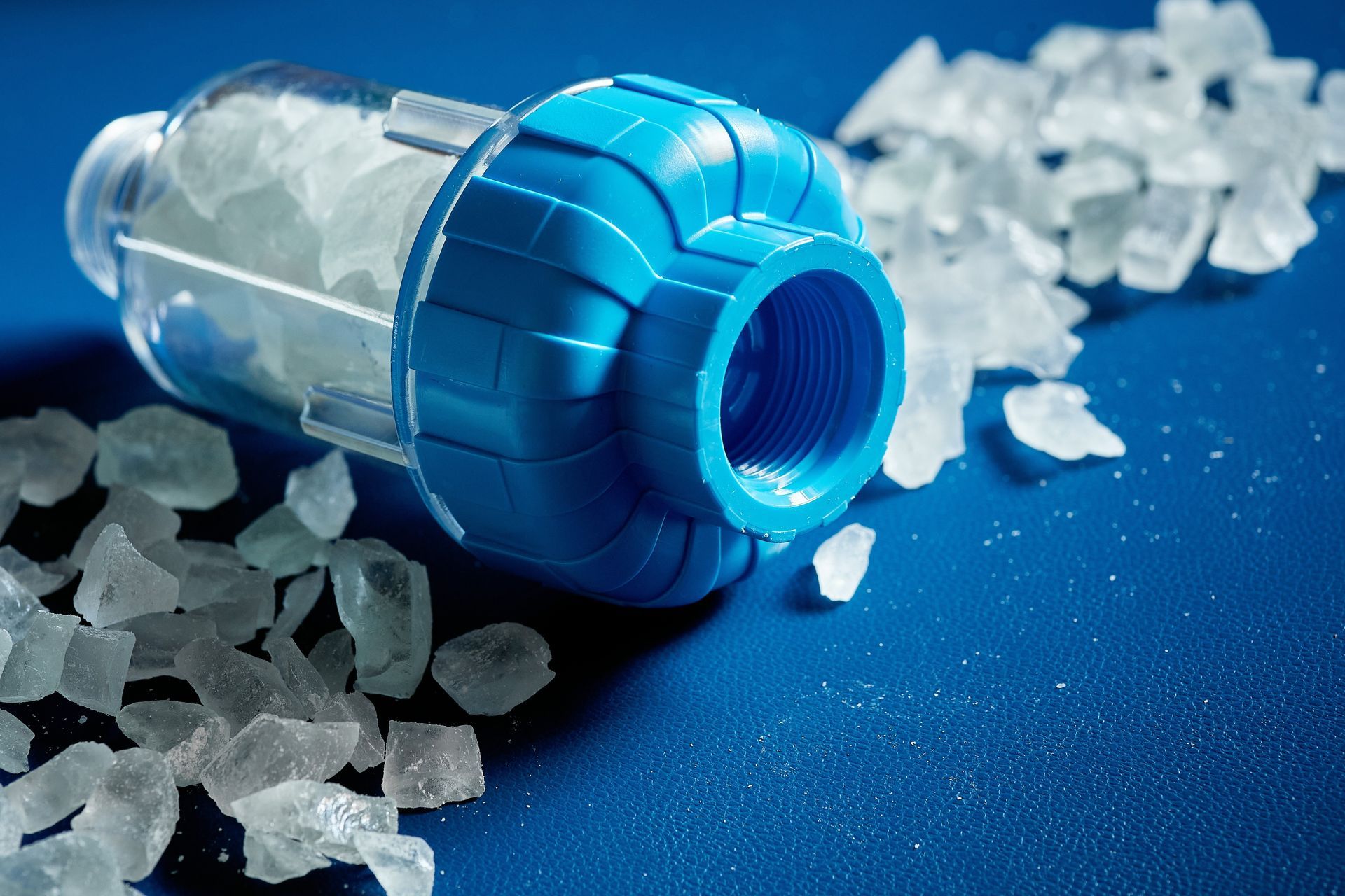 water filter with a crumb of salt crystals on a blue background.] 