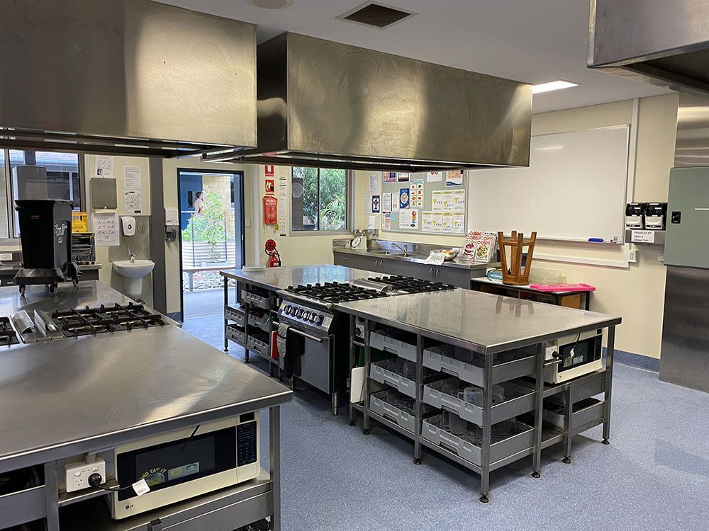 A Kitchen With a Lot of Stainless Steel Appliances and Tables — Clarry Anderson Sheet Metal Pty Ltd in Port Macquarie, NSW