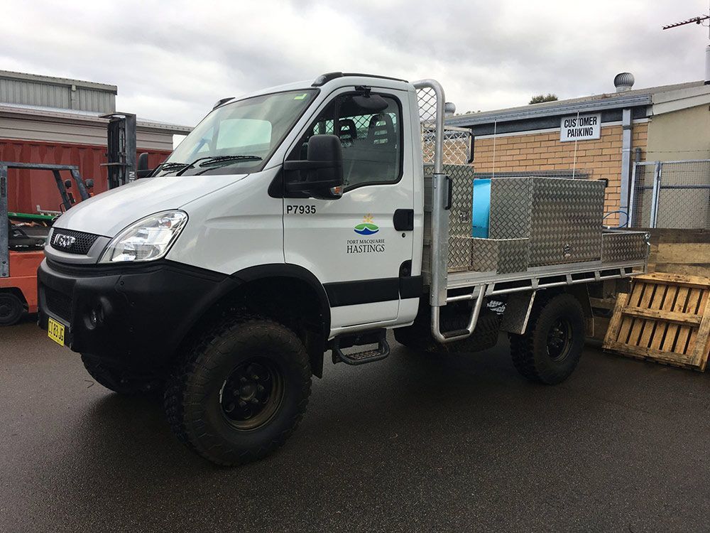 A White Truck With a Flatbed is Parked in Front of a Building — Clarry Anderson Sheet Metal Pty Ltd in Port Macquarie, NSW