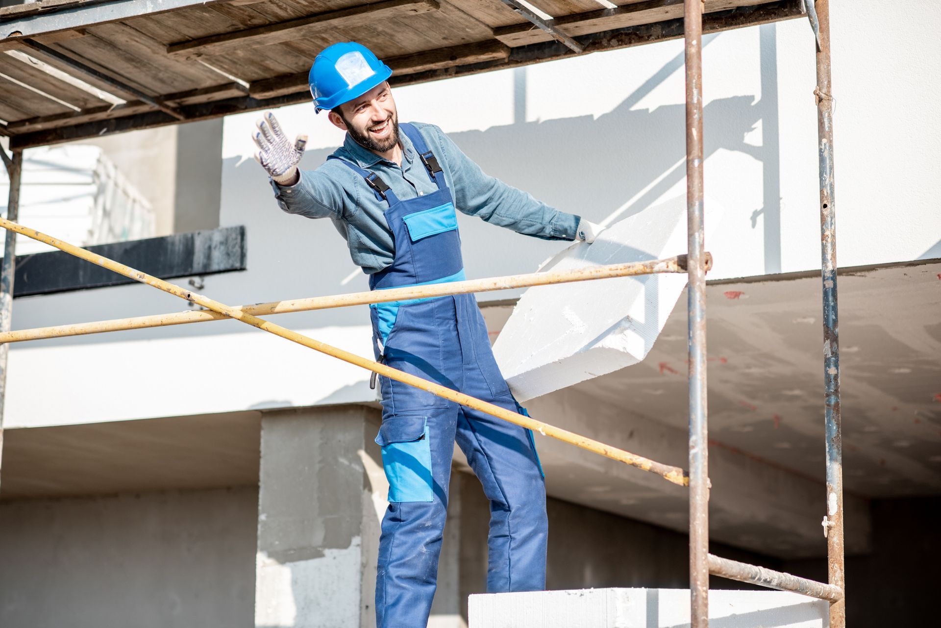 Person wearing a blue hard hat and overalls waving. Person wearing a blue hard hat and overalls waving.