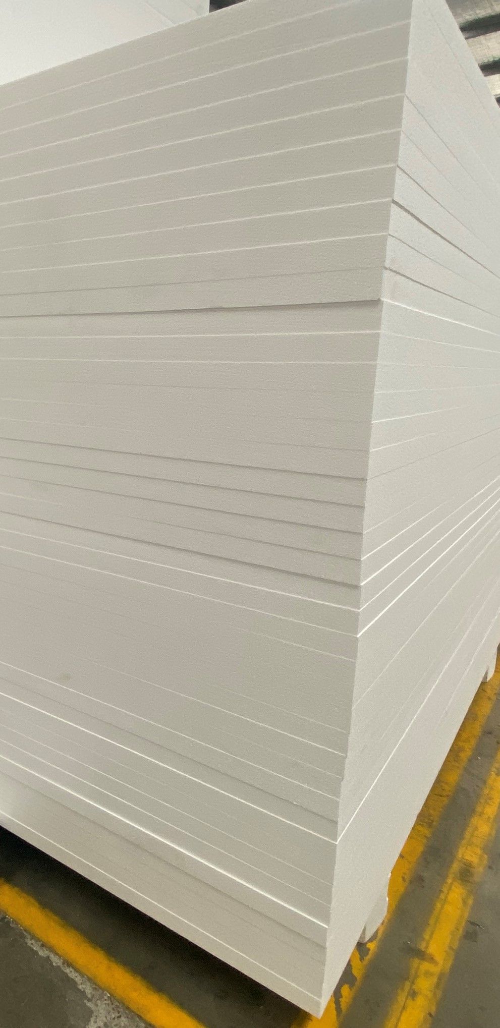 A stack of white styrofoam sheets sitting on top of each other on a pallet.