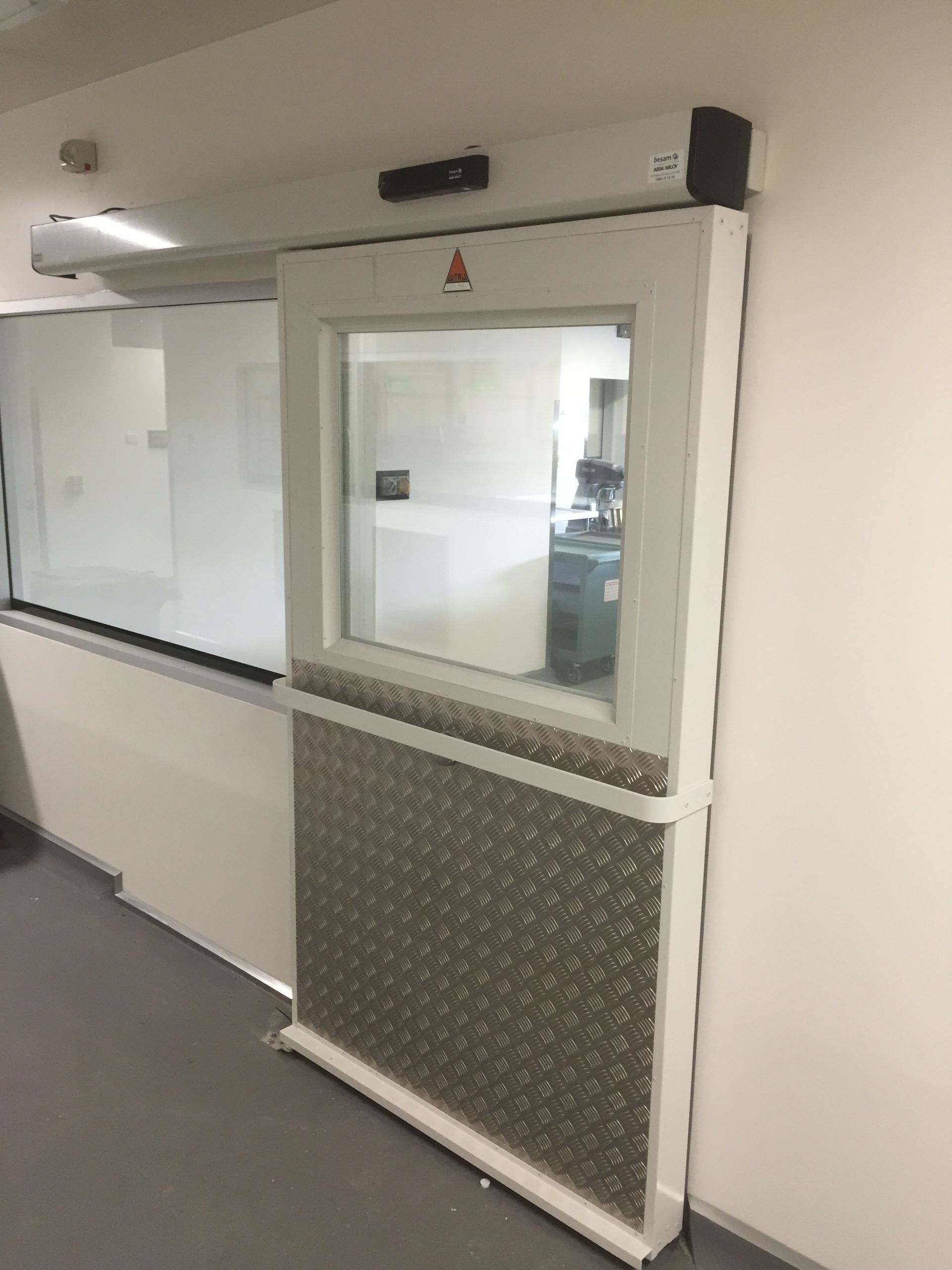 A sliding glass door with a window in a room.