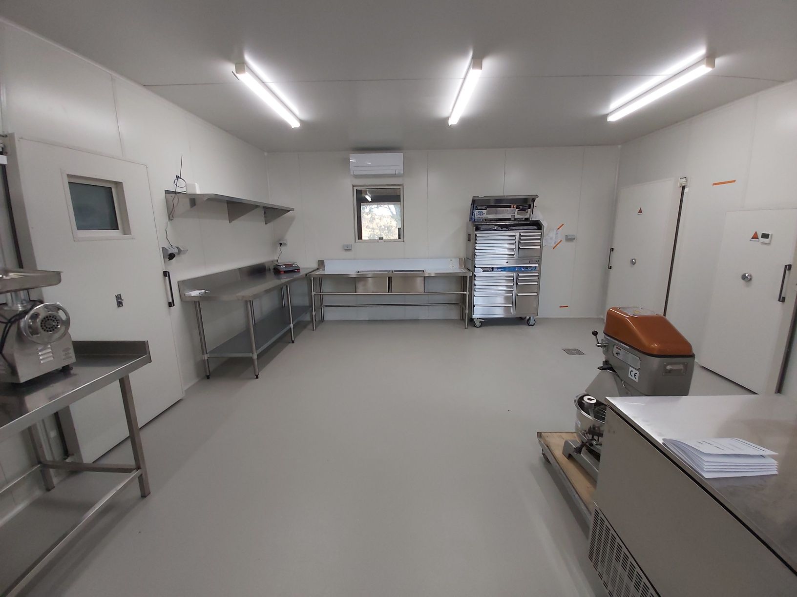 A large room with a lot of stainless steel appliances in it.