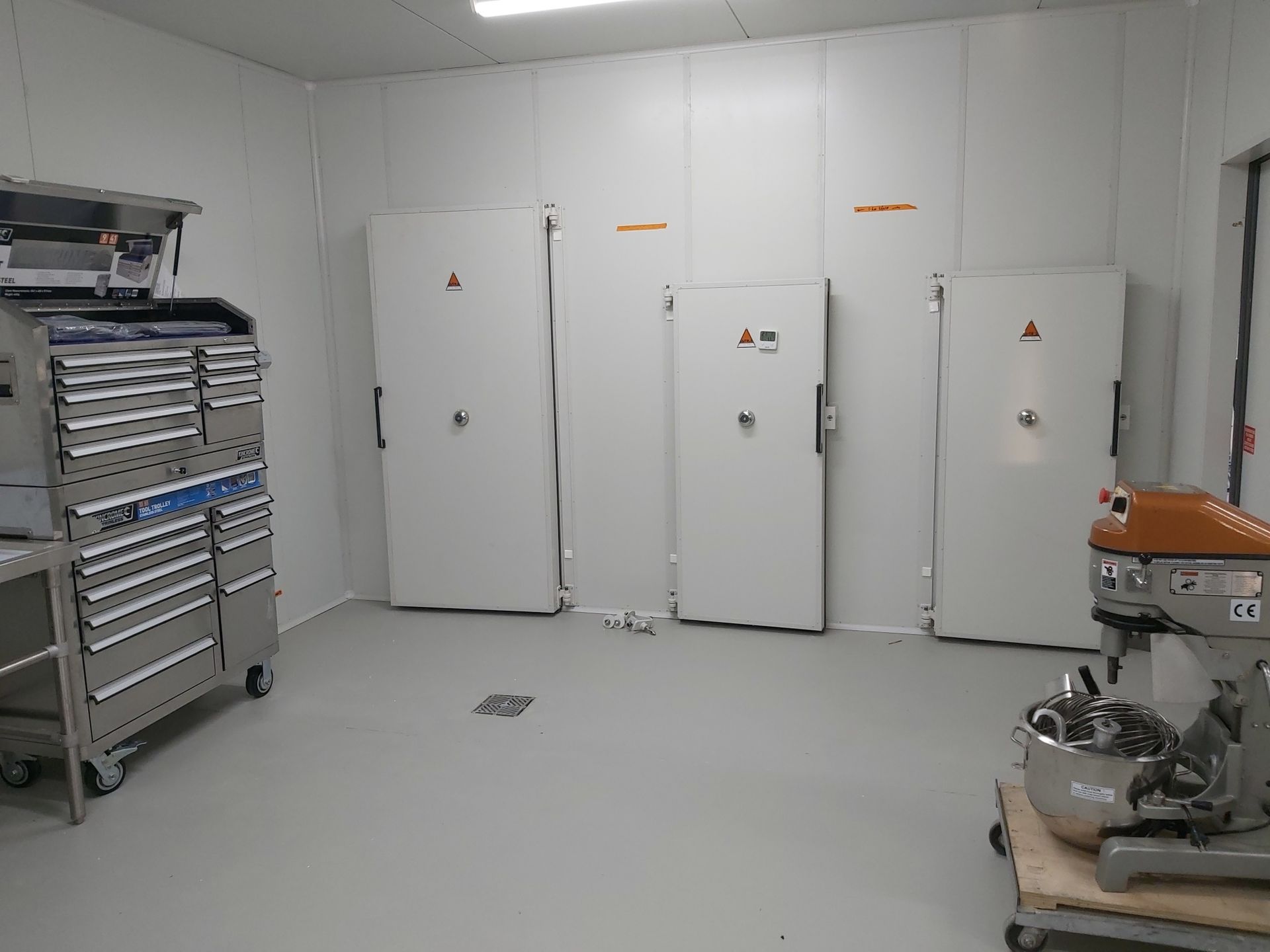 A room with a lot of white doors and a mixer in it.